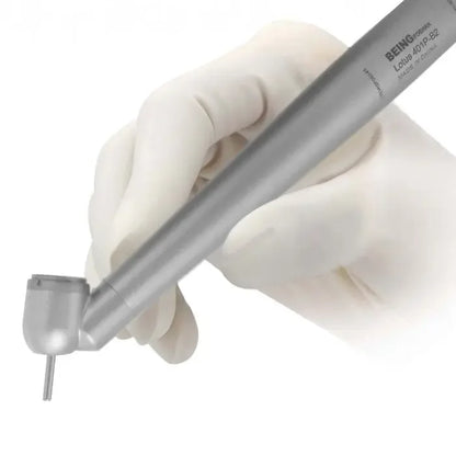 Gloved hand holding a 45-degree airotor dental handpiece with metal finish