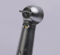 Close-up of a dental airotor handpiece with bur, black and metallic finish, on gray background